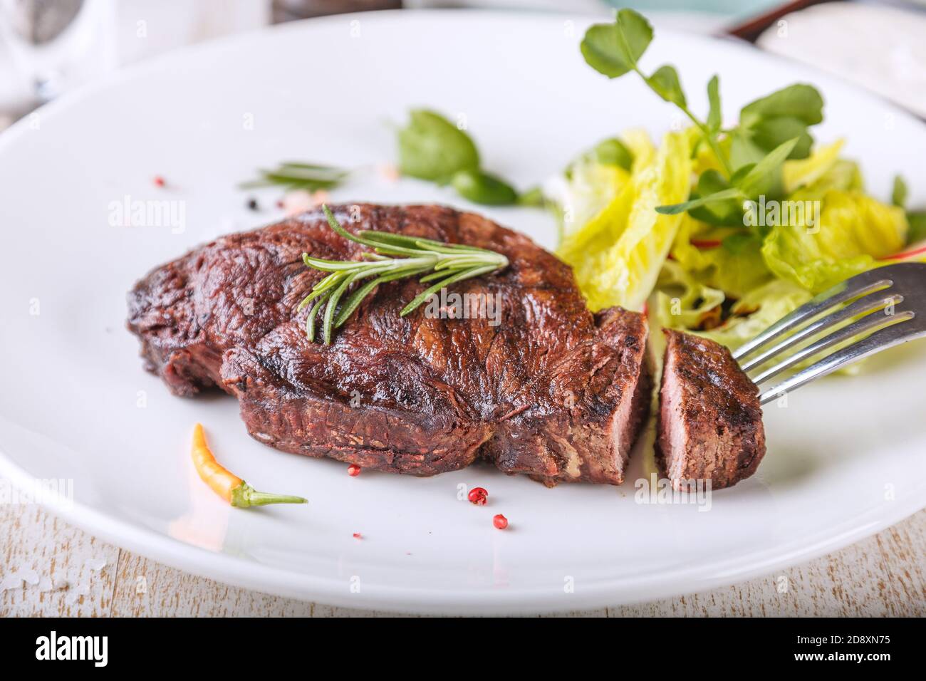 Sul piatto si trovano deliziose bistecche e insalata di Striploin Foto Stock