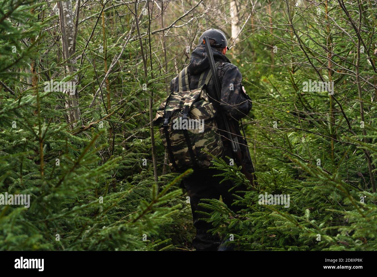 Hunter con una pistola e uno zaino nella a foresta Foto Stock