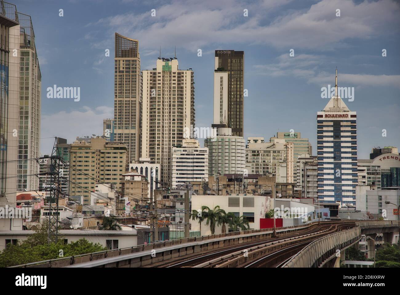 Questa foto unica mostra lo skyline di Bangkok in Thailandia, tra cui la ferrovia sopraelevata in primo piano e i grattacieli. Foto Stock