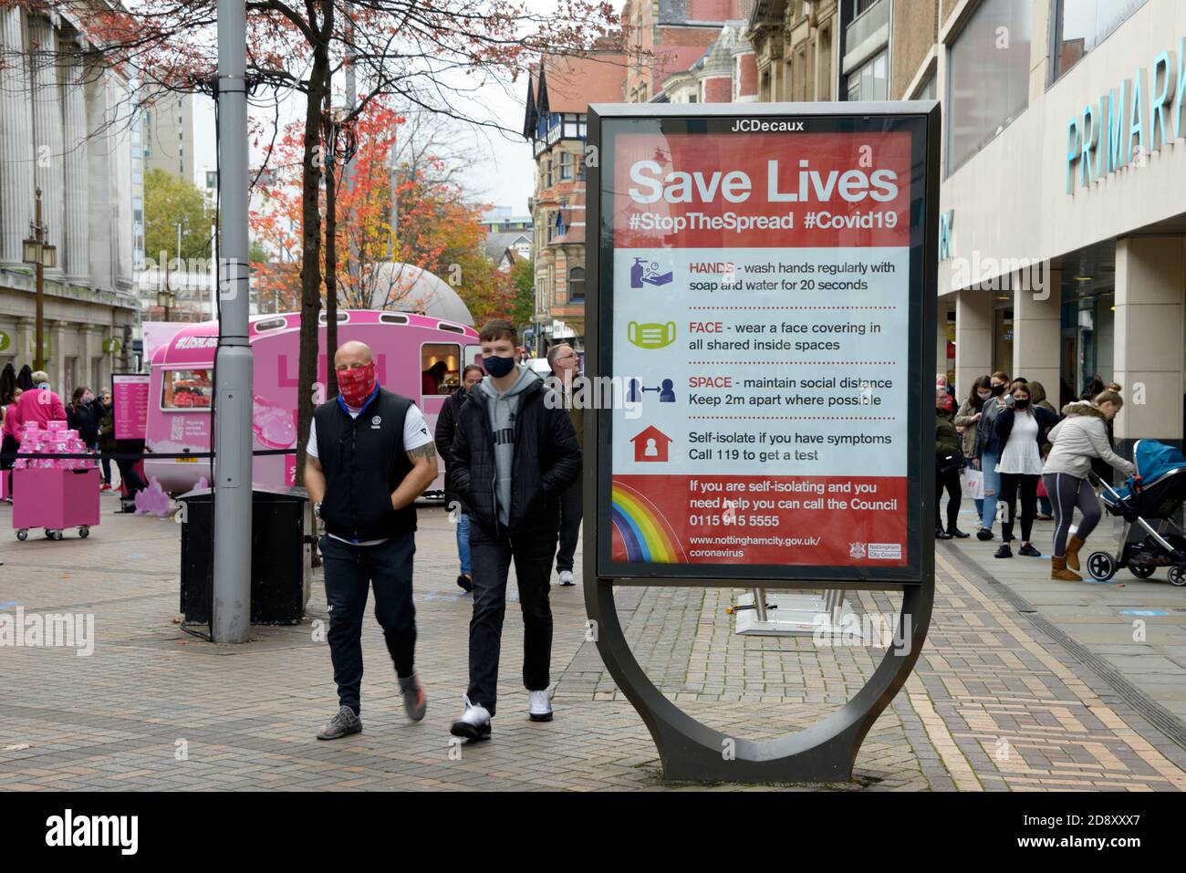 La gente cammina oltre il cartello stradale, 'Save Lives' Foto Stock