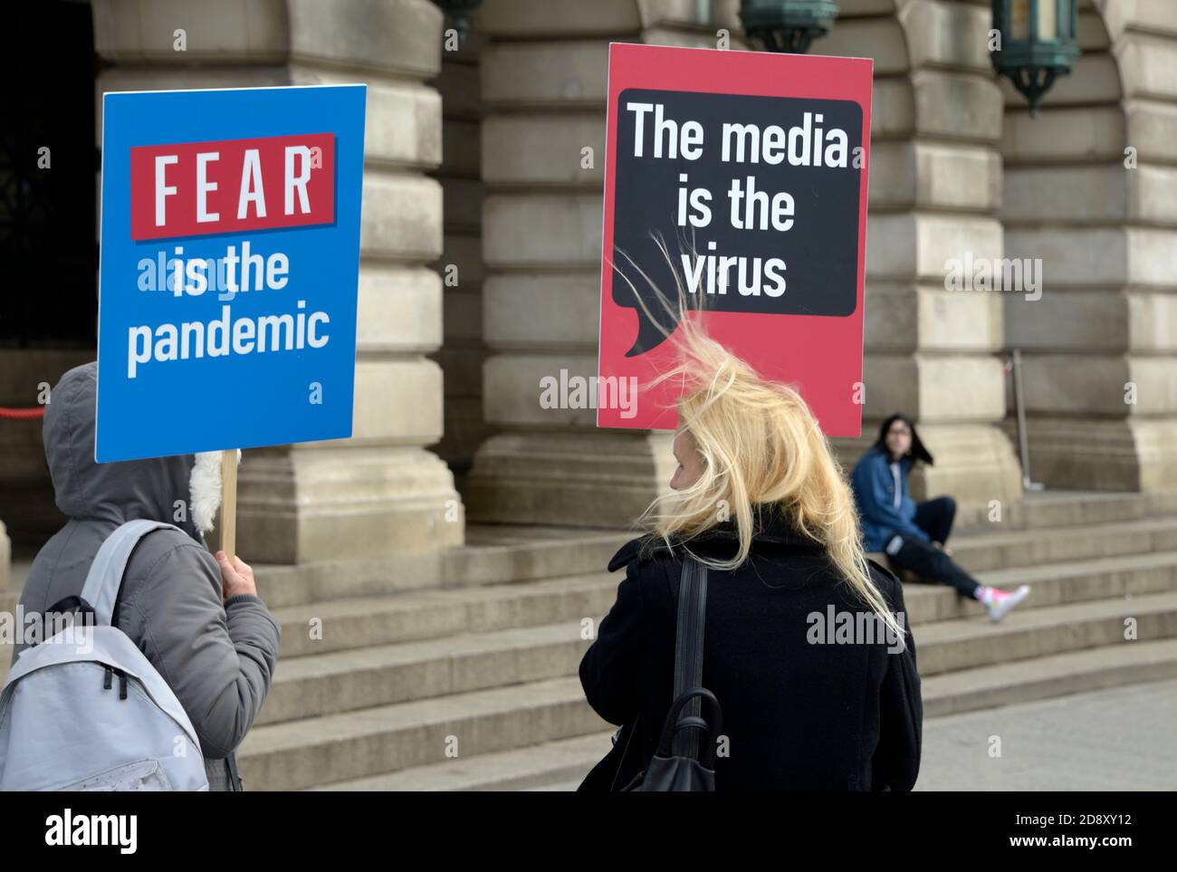 La gente alla riunione di teoria di cospirazione con i cartelli Foto Stock