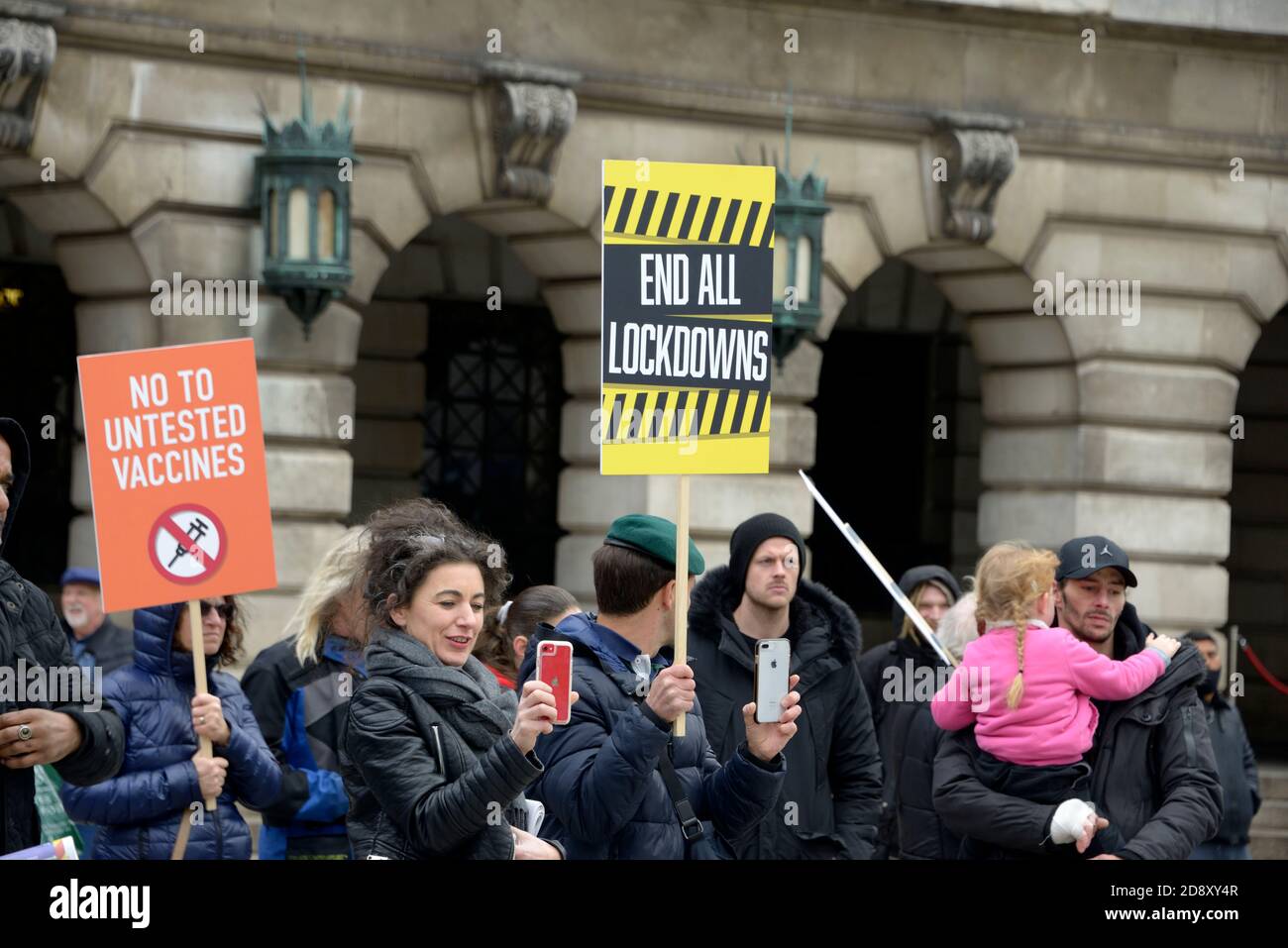 La gente alla riunione di teoria di cospirazione con i cartelli Foto Stock