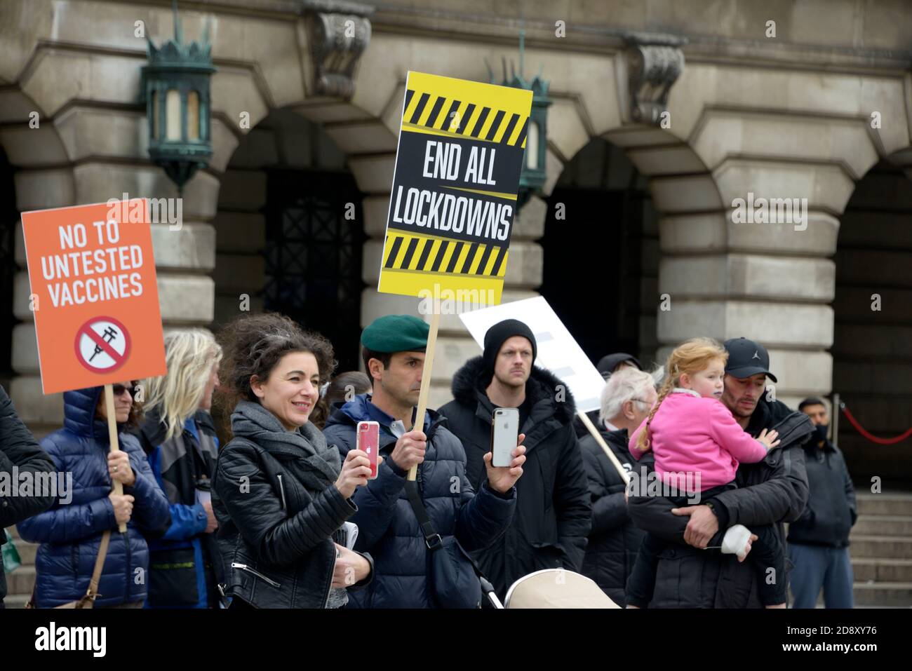 La gente alla riunione di teoria di cospirazione con i cartelli Foto Stock
