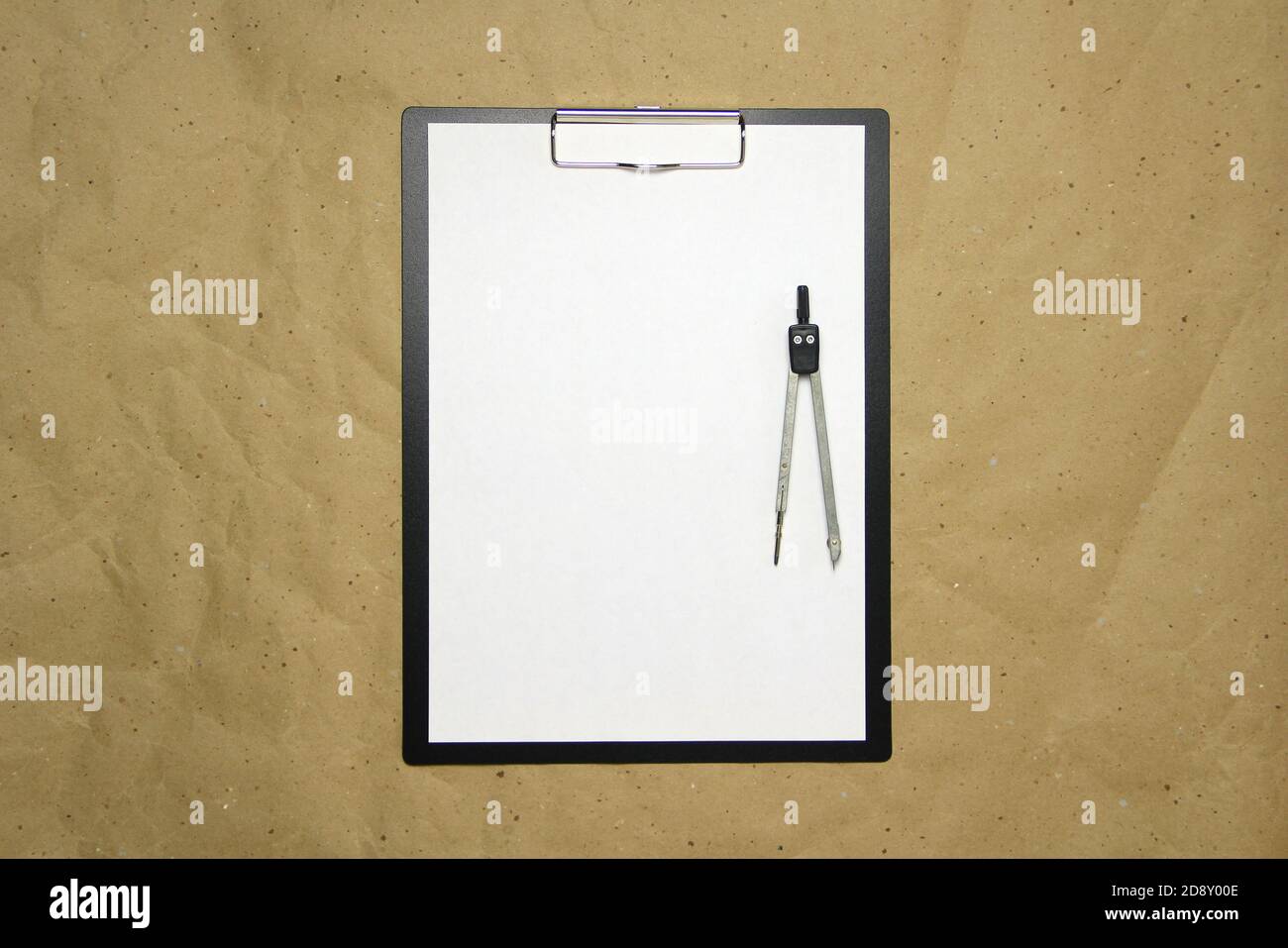 Una tavoletta con un foglio bianco di formato A4 con divisori su una carta da artigianato beige. Concetto di misurazioni, studi e costruzioni accurate. Foto di scorta con spazio vuoto per il testo e il disegno. Foto Stock