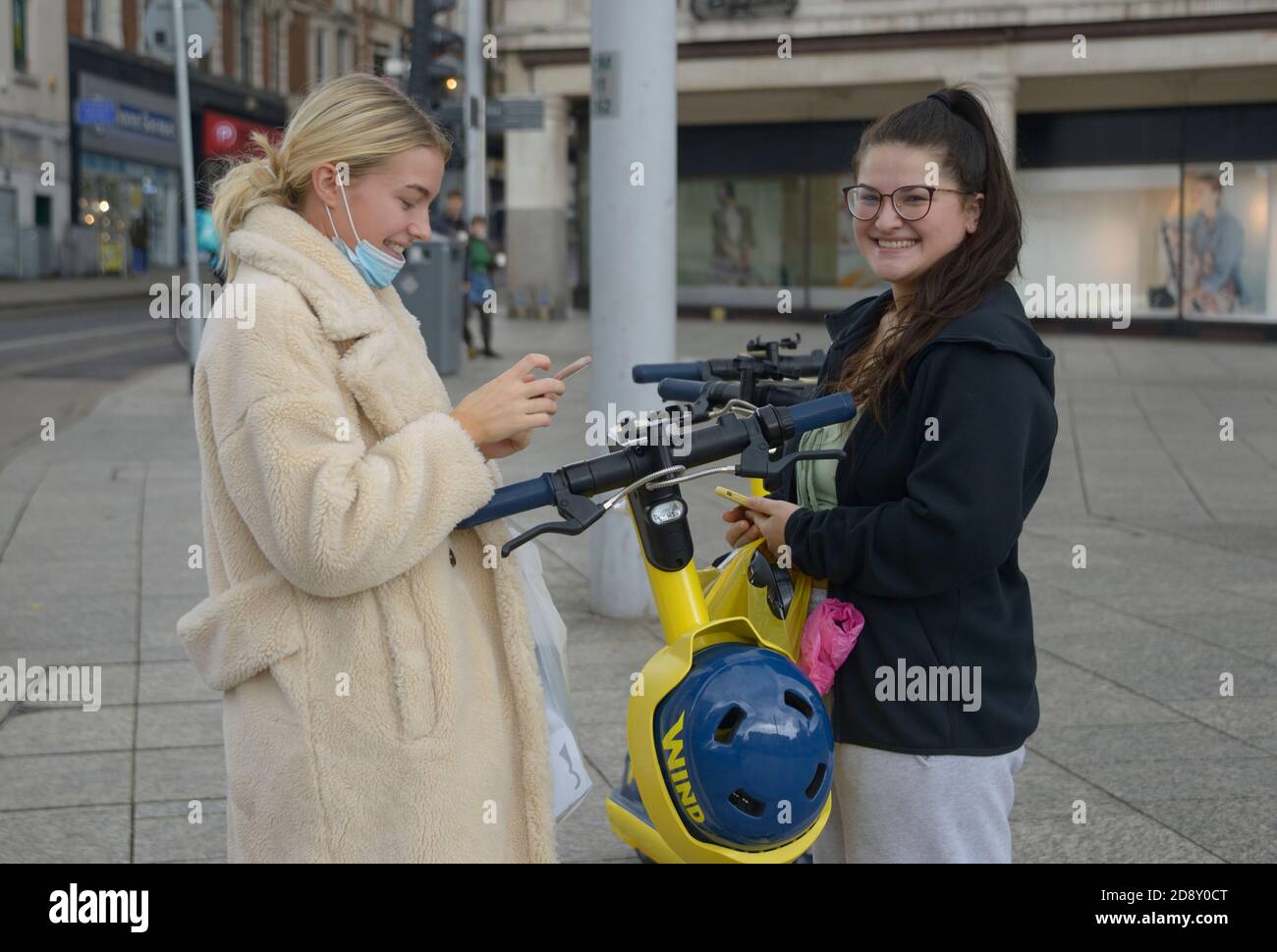 Giovani donne che provano gli scooter elettrici. Foto Stock