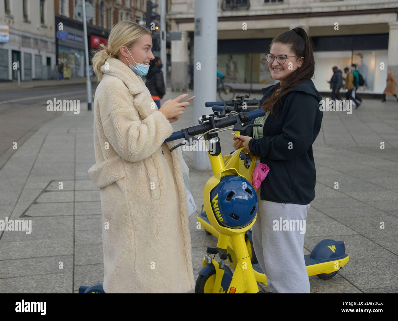 Giovani donne che provano gli scooter elettrici. Foto Stock