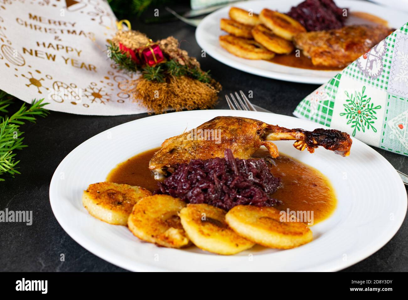 delizioso piatto con cena di natale. coscia d'anatra arrosto con cavolo rosso e gnocchi di patate fritte Foto Stock