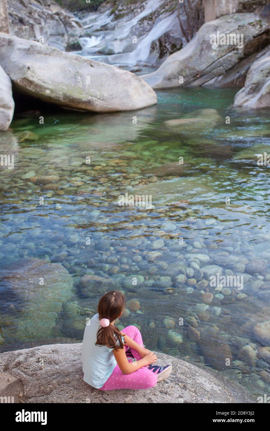 Bambina seduta sul lungofiume della gola di Los Pilones alla Riserva Naturale Garganta de los Infiernos. Posto eccezionale per godersi la natura Extremadura Foto Stock