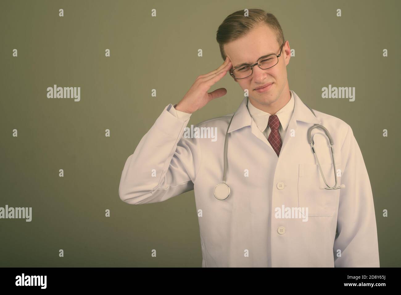 Giovane uomo bello medico contro sfondo colorato Foto Stock