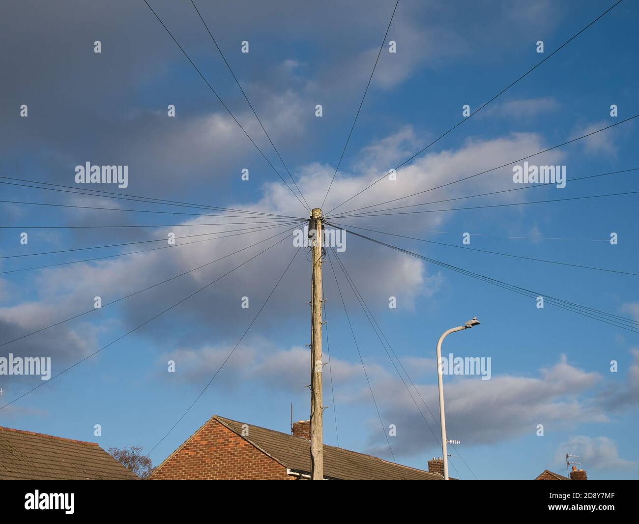 Un polo in legno British Telecom (BT) utilizzato per collegare gli utenti domestici ai servizi telefonici e a banda larga. Preso in un ambiente urbano in una giornata di sole con l Foto Stock