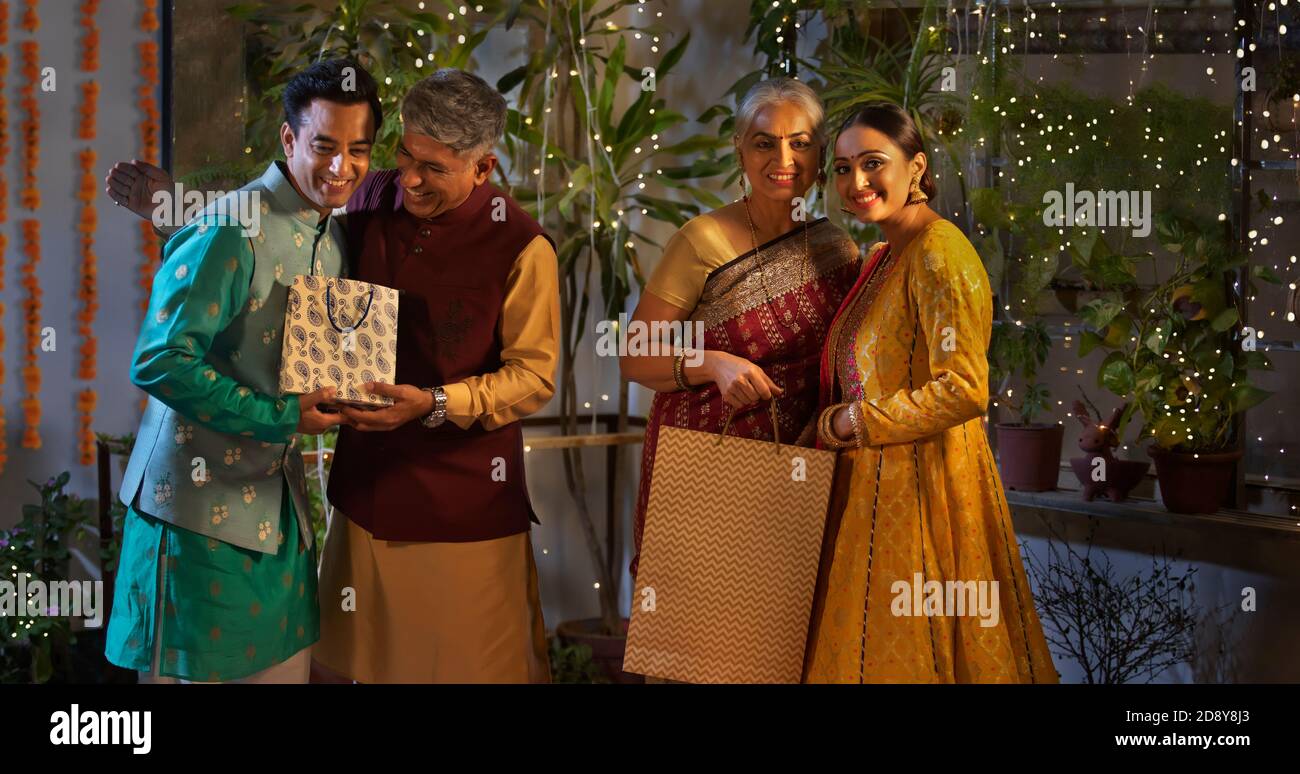 RITRATTO DI UNA FAMIGLIA FELICE CHE SI POSA TRA LORO DONI DIWALI Foto Stock