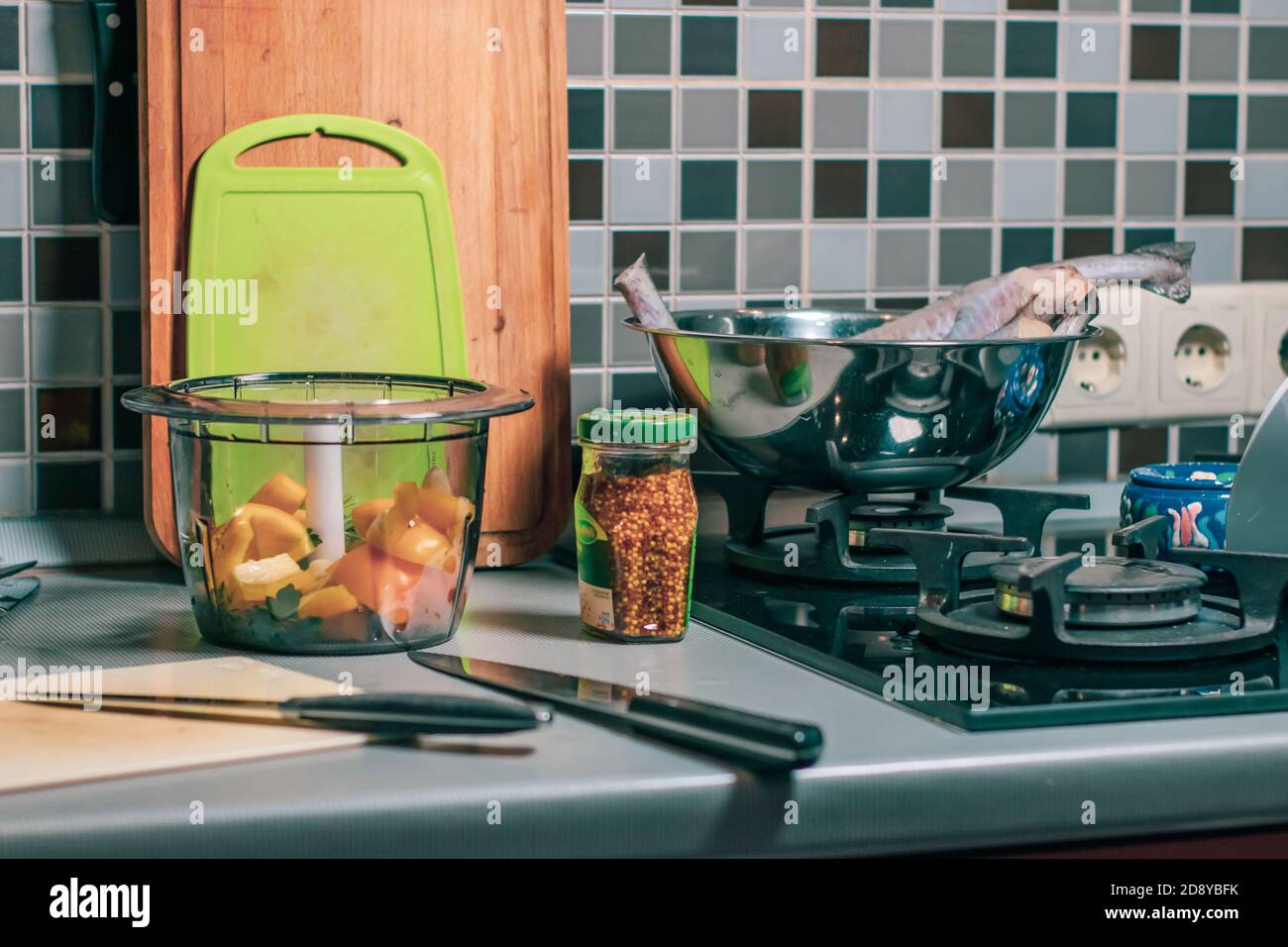 Bottiglia di senape, frullatore e taglieri in cucina casalinga. Atmosfera accogliente Foto Stock
