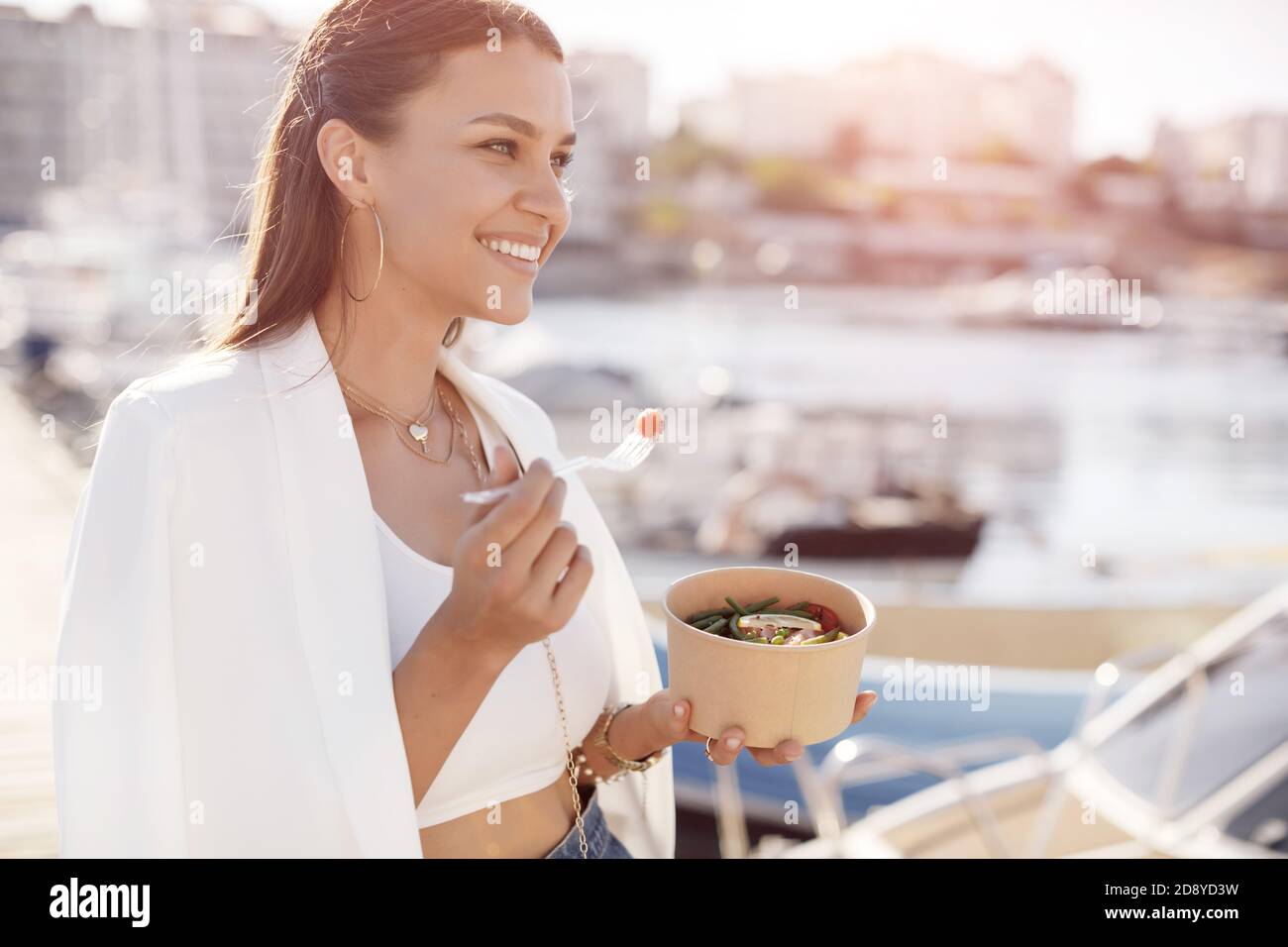 Donna felice con ciotola fitness cibo all'aperto Foto Stock