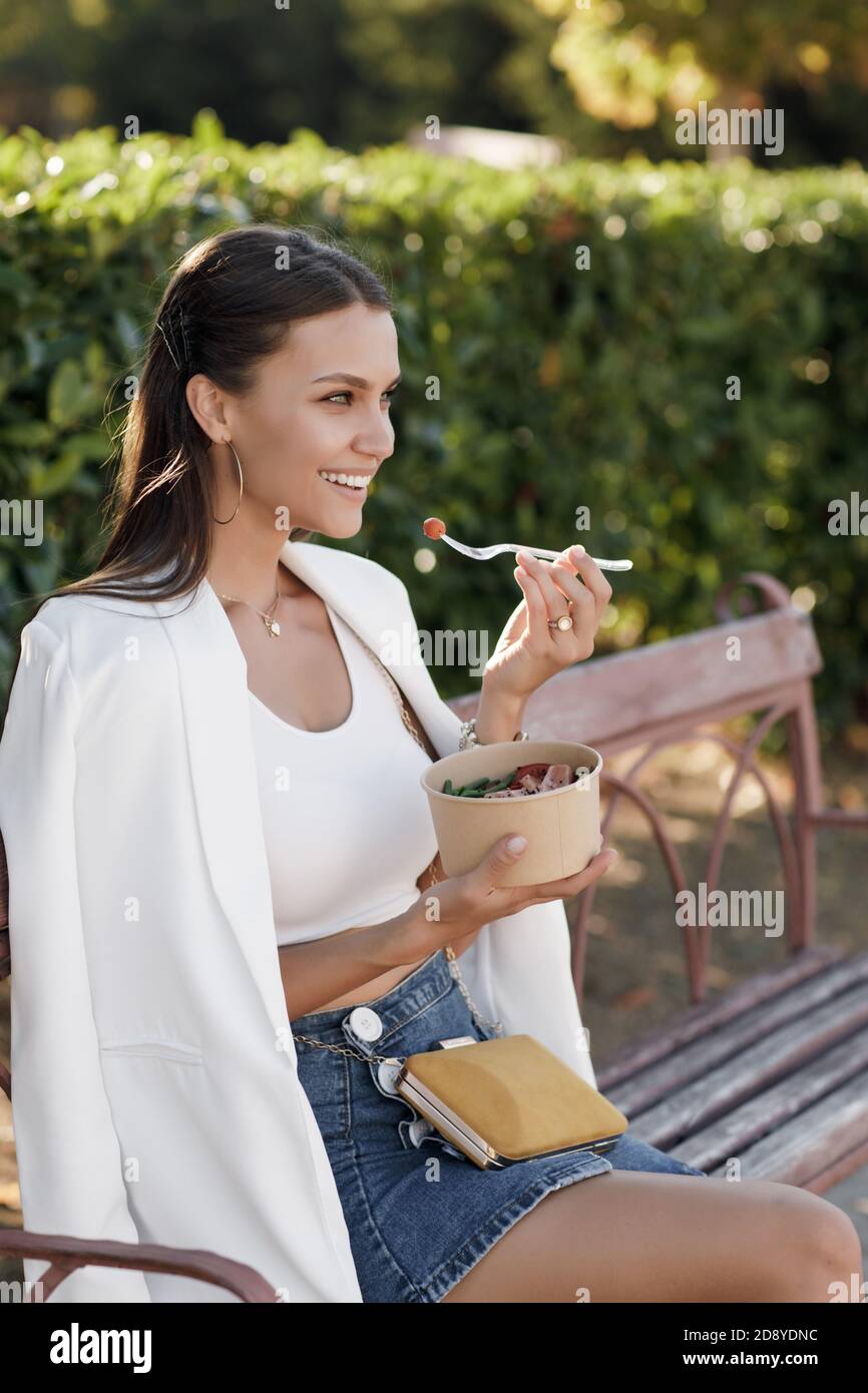 Donna felice con ciotola fitness cibo salmone e verdure, caucasica donna all'aperto Foto Stock