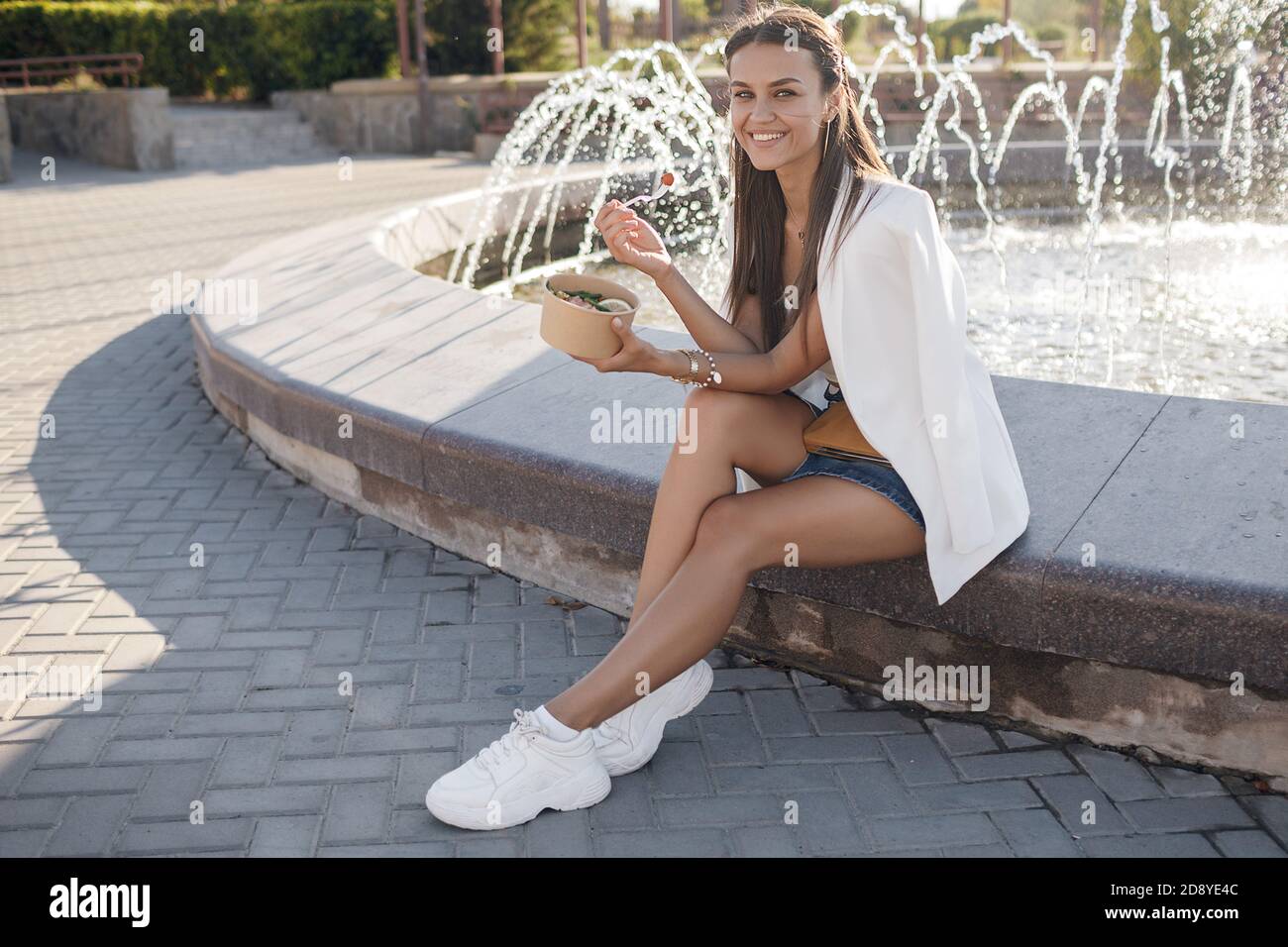 Donna felice con ciotola fitness cibo salmone e verdure, caucasica donna all'aperto Foto Stock