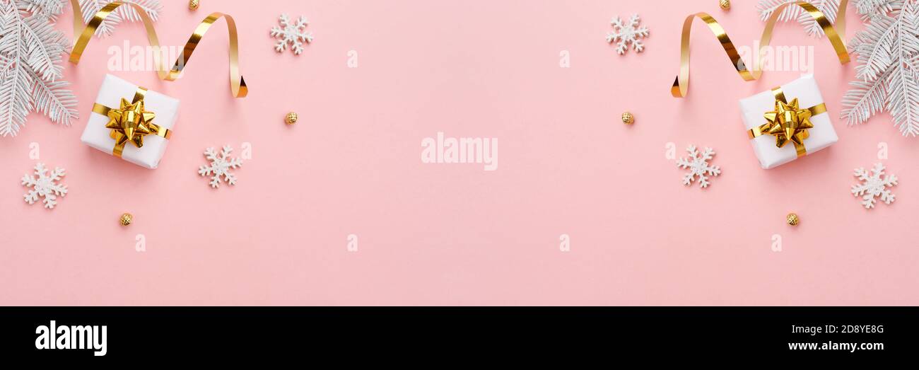 Ornamento natalizio con decorazioni in oro su sfondo rosa pastello Foto Stock