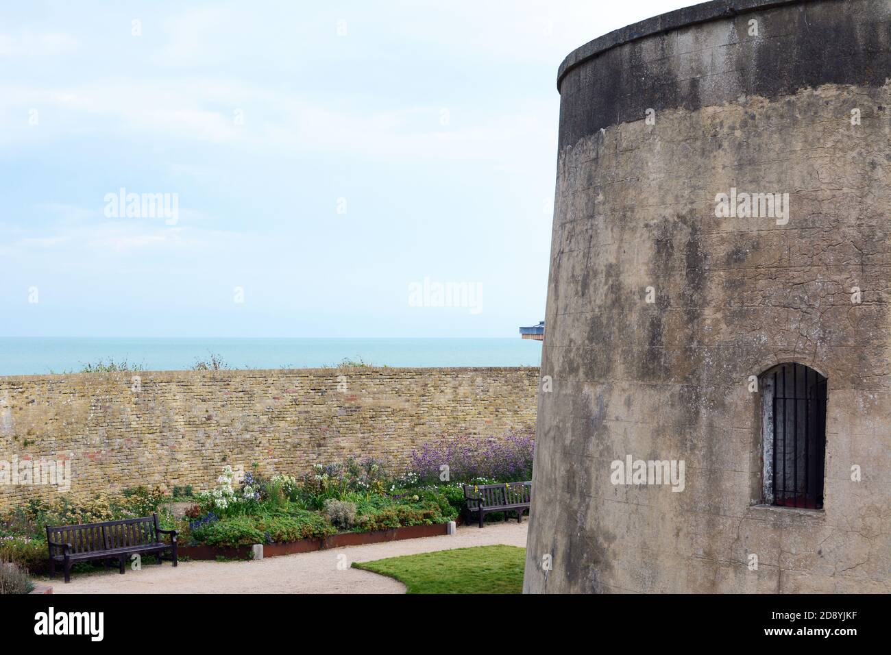 Wish Tower e graziosi giardini di fiori murati ad Eastbourne, East Sussex. La Torre del martello fu costruita all'inizio del XIX secolo per difendere l'inglese Foto Stock