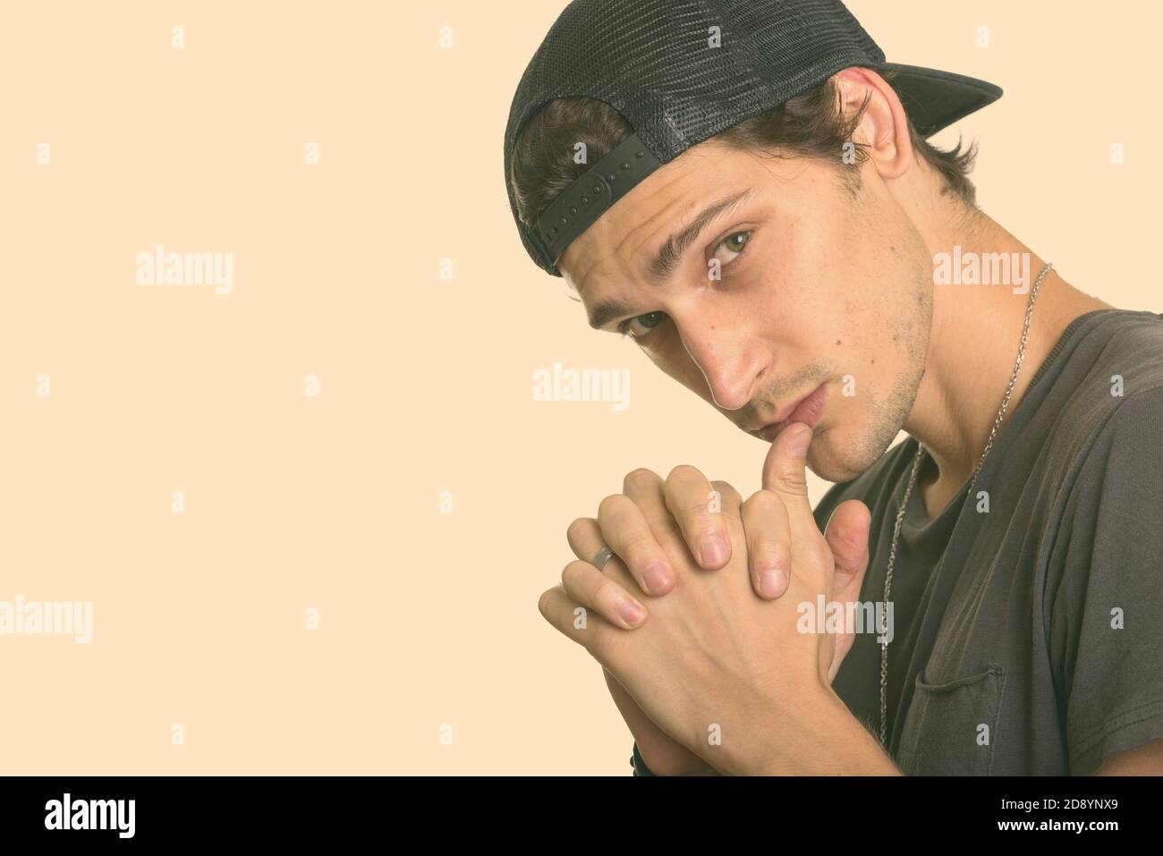 Primo piano di un giovane bell'uomo che indossa un attacco mentre si intreccia le dita Foto Stock