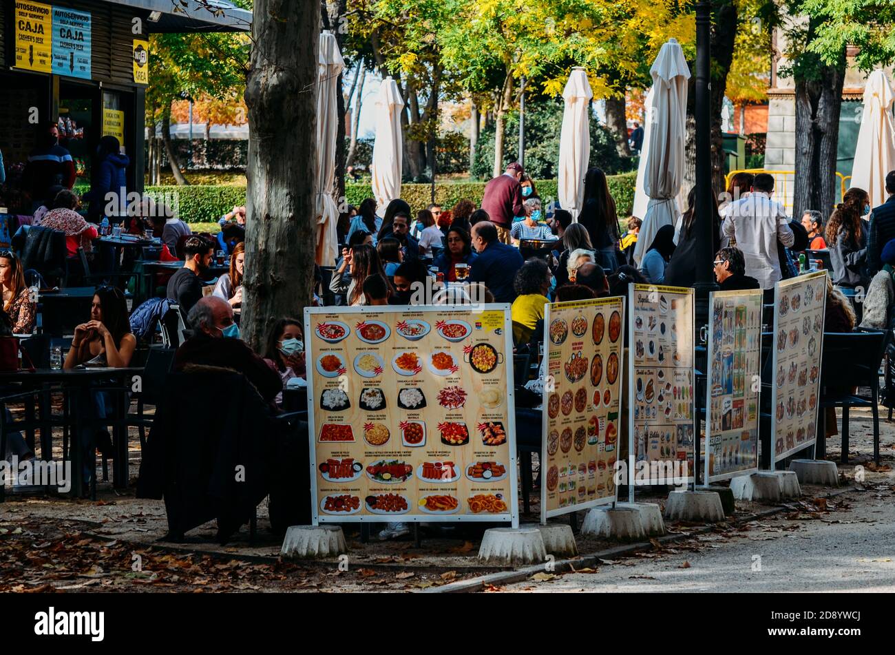 La gente siede in un patio della terrazza nel 'Parco El Retiro' in autunno, Madrid, Spagna Foto Stock