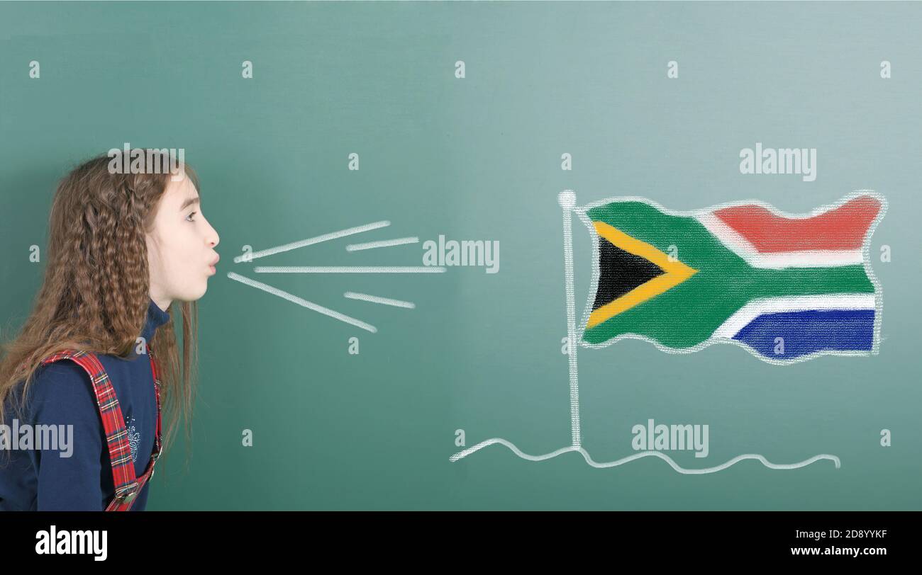 Ragazza pre-adolescente che soffia sul bordo della scuola disegnata sulla bandiera del Sud Africa lavagna. Foto ad alta risoluzione. Profondità di campo completa. Foto Stock