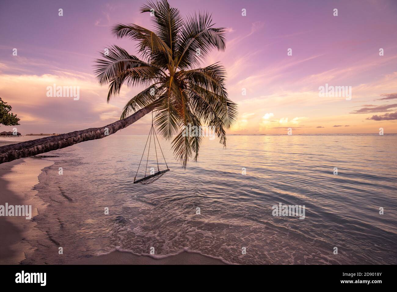 Incredibile spiaggia con palme e altalena al tramonto. Bellissimo tramonto su sfondo tropicale spiaggia di mare per viaggiare in vacanza relax tempo Foto Stock