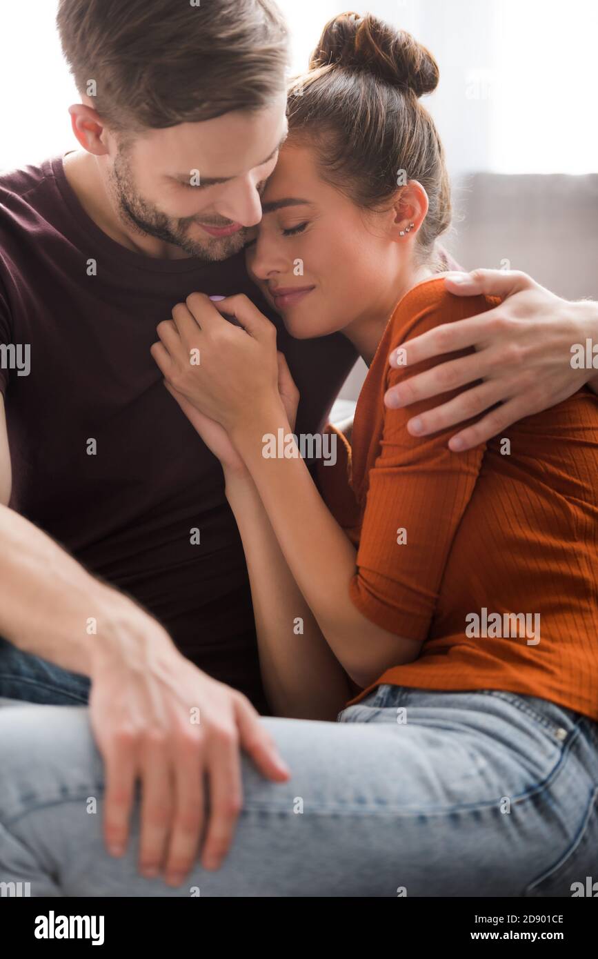 giovane uomo abbracciando la ragazza sconvolgente mentre la calmava a casa Foto Stock