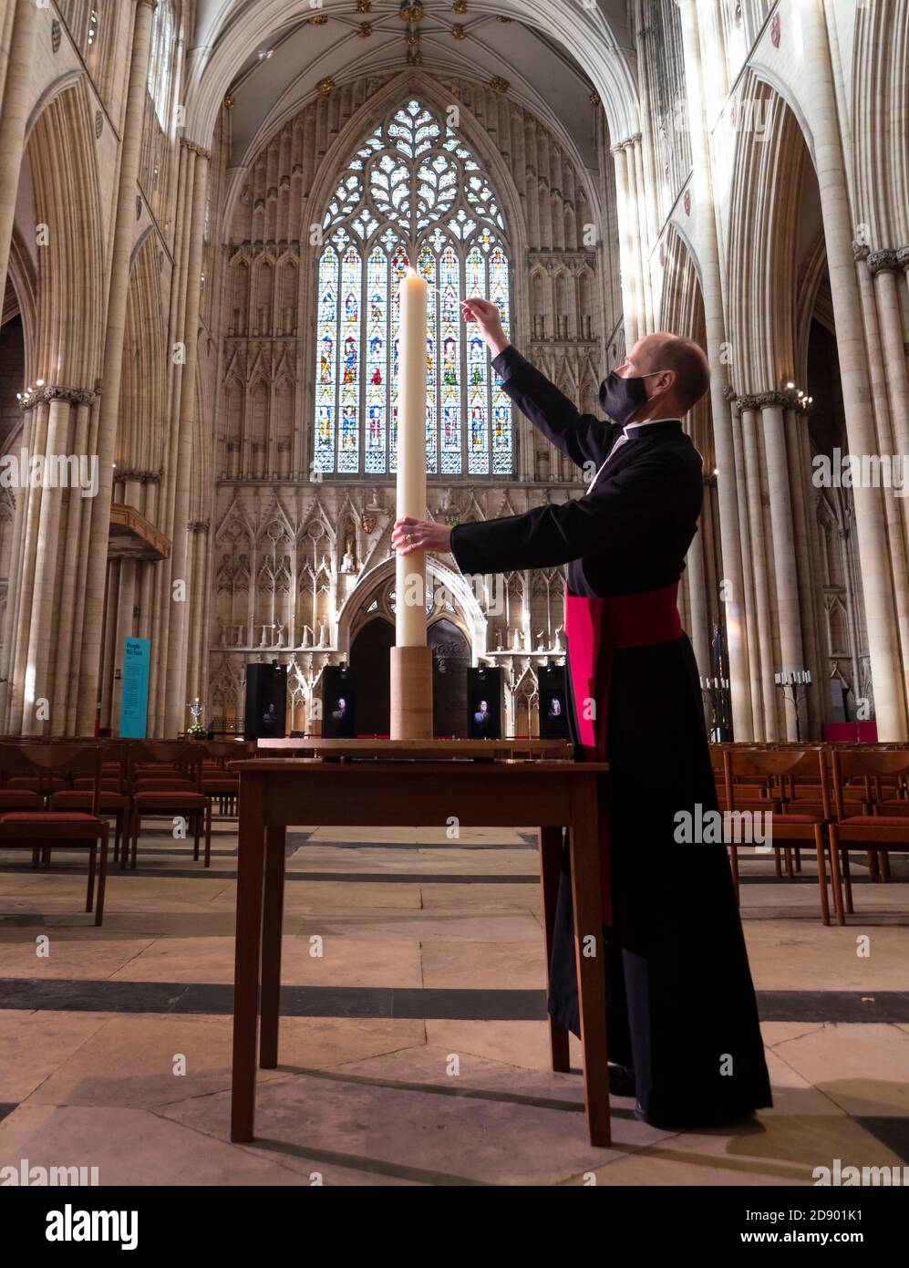 Il Revd Michael Smith, il canonico Pastore della cattedrale di York, accende una candela durante il periodo della memoria della cattedrale, che continua oggi con uno speciale "Day to Remember" coloro che sono morti durante il 2020. Foto Stock