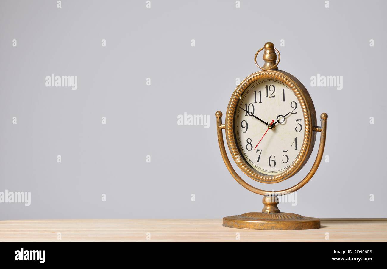 Orologio vintage Table Metal su sfondo grigio Foto Stock