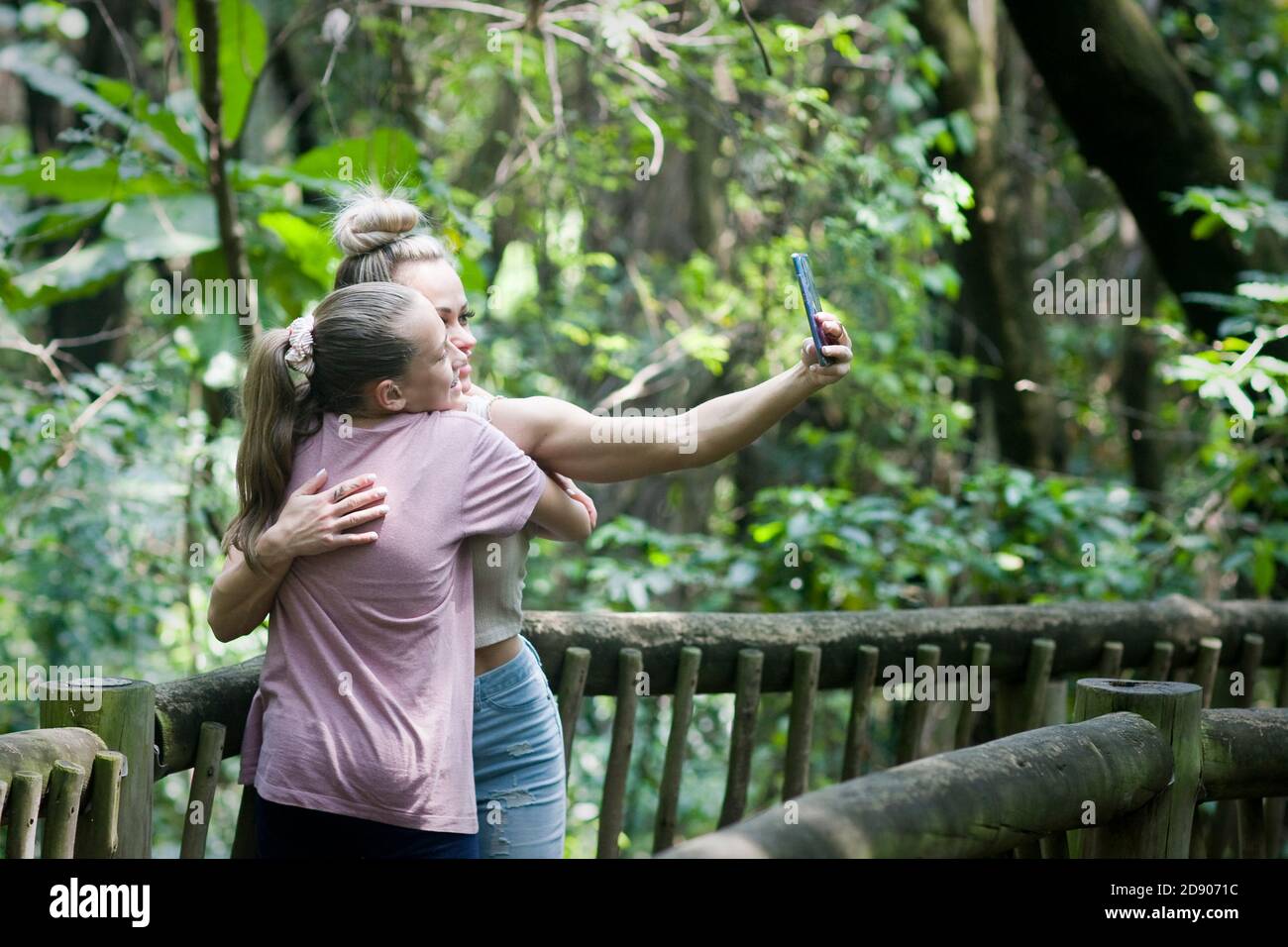 Una madre e una figlia scattano una foto selfie in un parco. Foto Stock