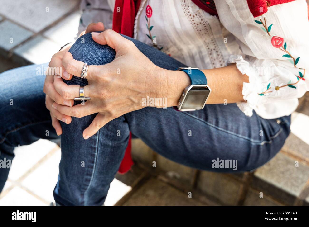 Donna seduta in dolore con ginocchia sulle scale Foto Stock