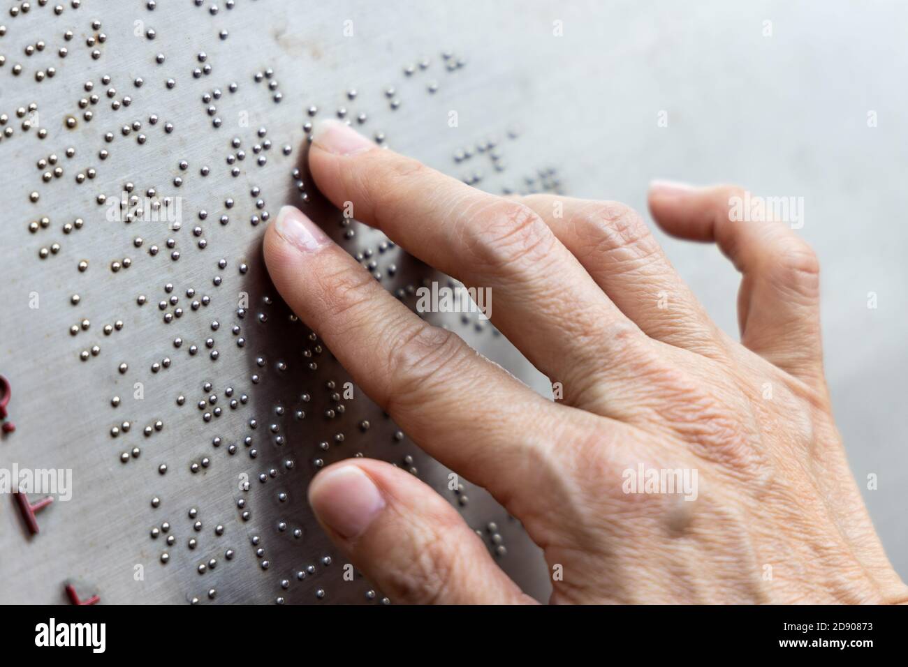 Lettura delle dita braille tattile sulla bacheca del parco pubblico Foto Stock