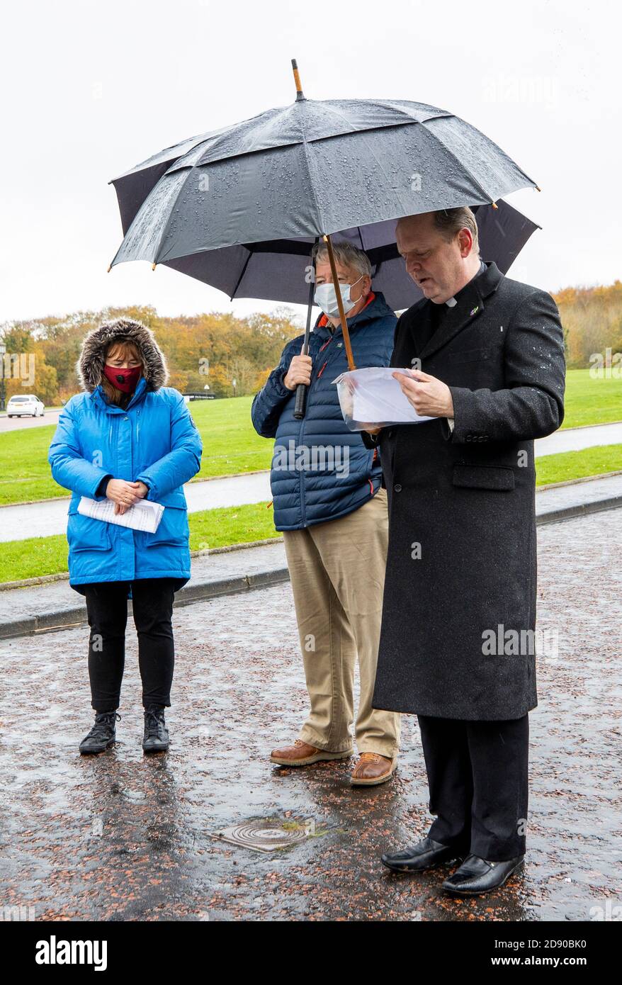 Padre Joe Gormley (a destra) di San MaryÕs Cregan recita preghiere prima di una silenziosa passeggiata per i scomparsi a Stormont con Sheila Simons (a sinistra) sorella di Eugene Simon con Oliver McVeigh (al centro) fratello di Columba McVeigh durante la quattordicesima passeggiata annuale di tutte le anime. Foto Stock