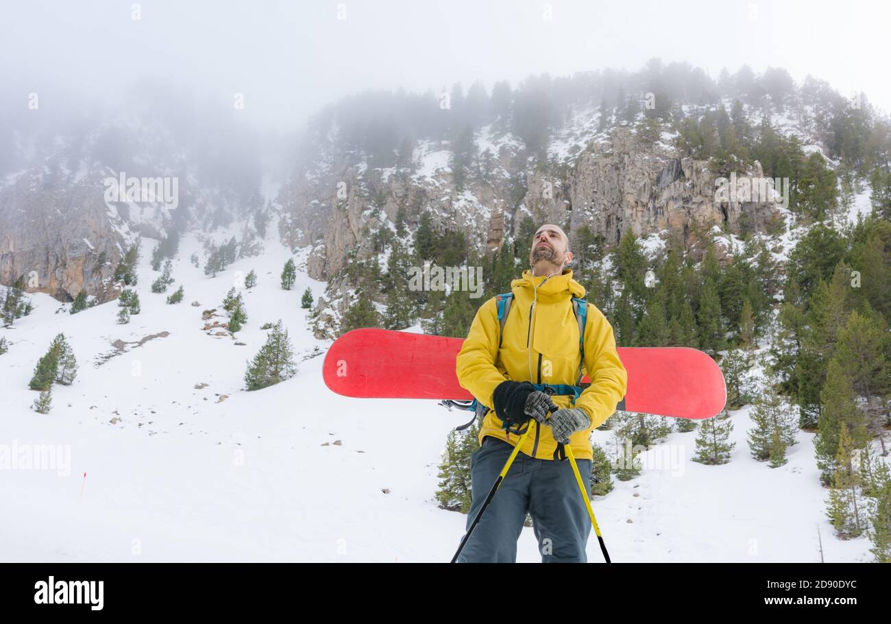 Pilota libero che saliva la montagna con il suo snowboard a. scendi la neve Foto Stock