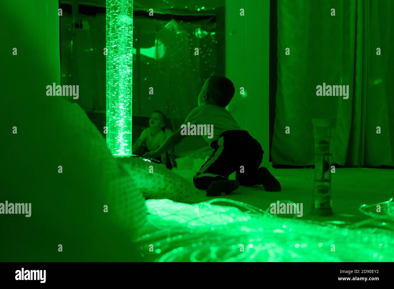 Bambino con disabilità intellettuale in sala sensoriale stimolante, snoezelen. Bambino autistico che interagisce durante la sessione di terapia. Foto Stock