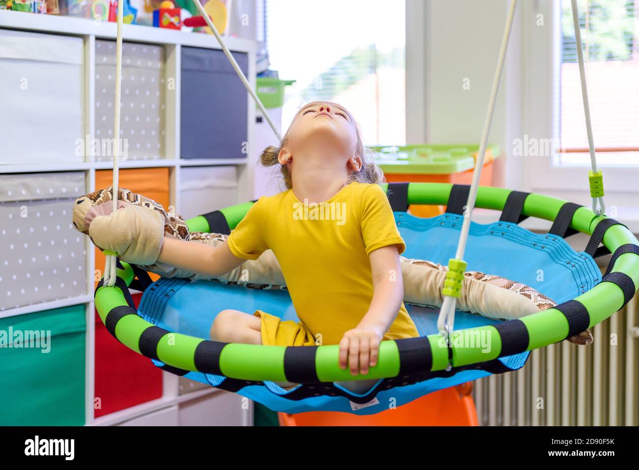 Cute ragazza di età prescolare che gioca con i giocattoli durante la terapia professionale. Foto Stock