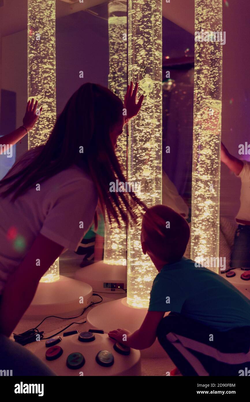 Esigenze speciali bambino in sala sensoriale stimolante, snoezelen. Bambino autistico che interagisce con il terapeuta durante la sessione di terapia. Foto Stock