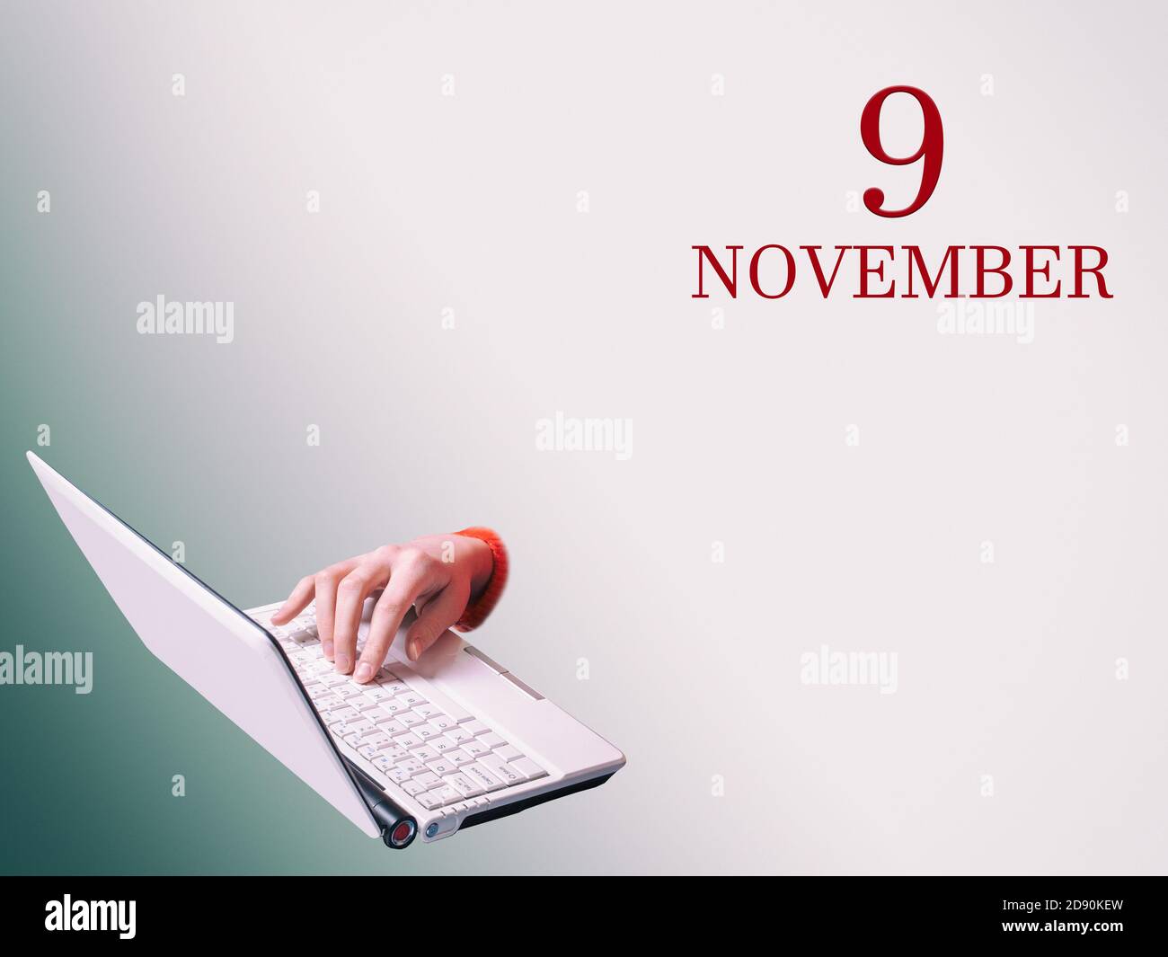 9 novembre. Una mano sta digitando su un computer portatile l'annuncio della data di una riunione o di un evento aziendale Foto Stock