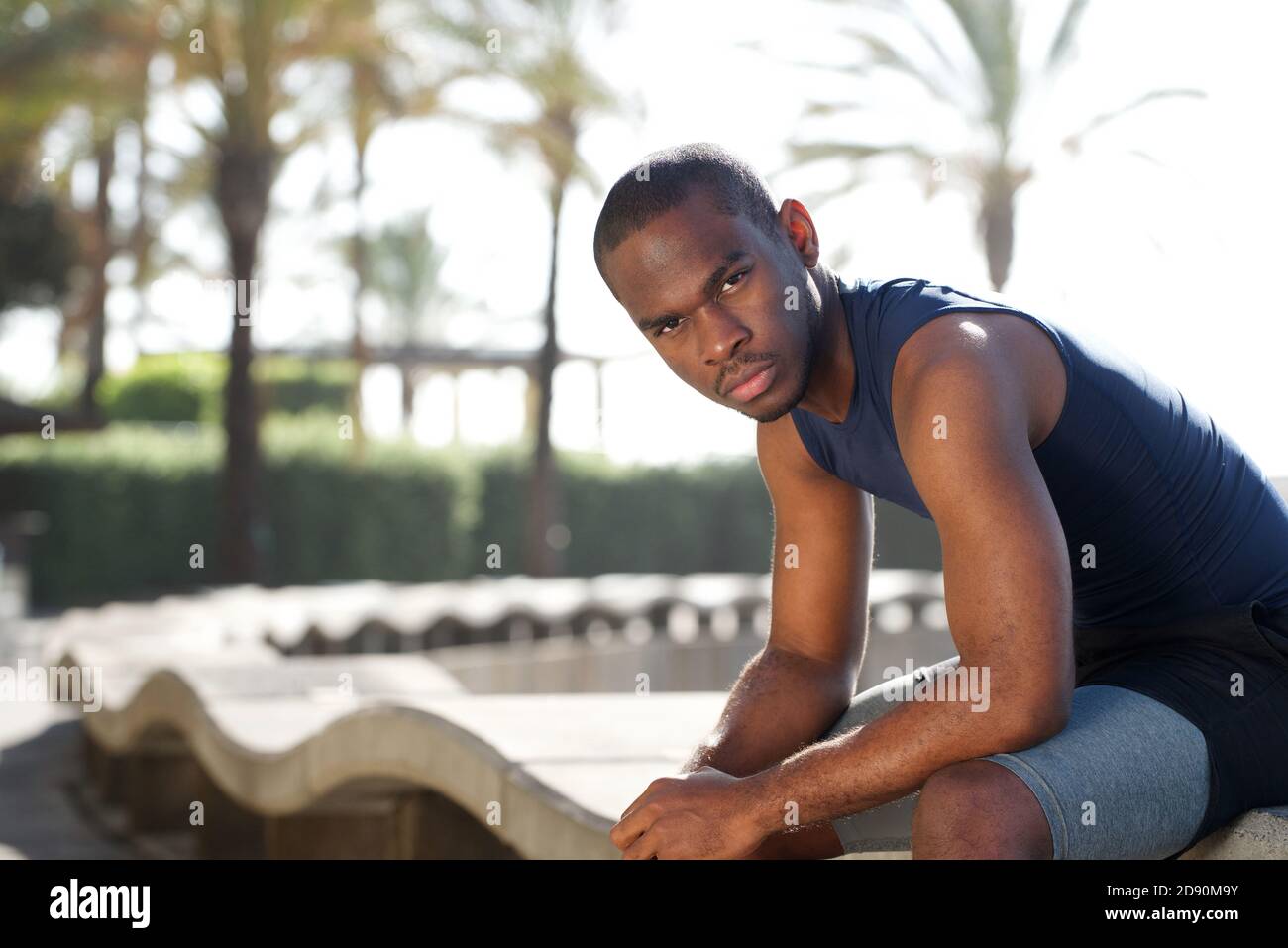 Ritratto di giovane e fresco sportivo nero seduto fuori Foto Stock