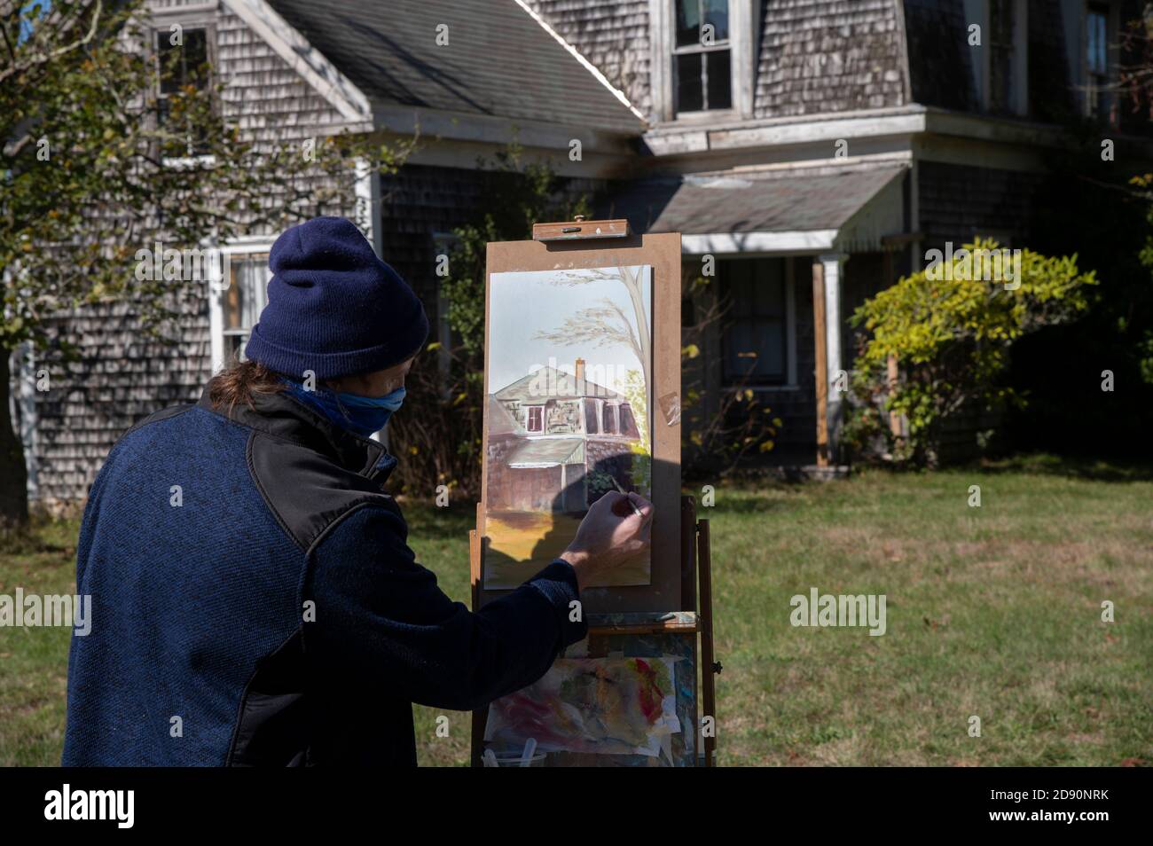 Un artista al lavoro che dipinge la storica fattoria Fuller a Barnstable, Massachusetts, USA in una tarda mattinata autunnale Foto Stock