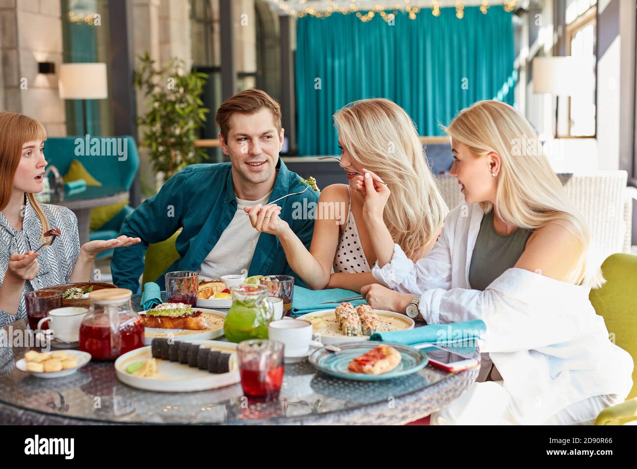 felici giovani amici caucasici che si riuniscono in caffetteria, seduti a tavola, chiacchierando, parlando.they stanno trascorrendo il tempo divertente, gli studenti o i migliori amici che si incontrano Foto Stock