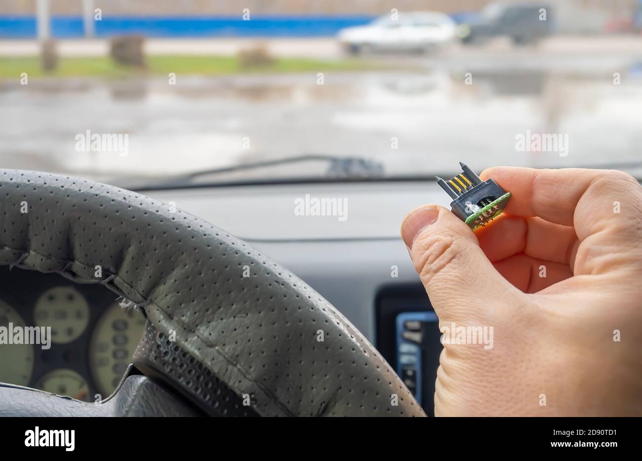 vista di un microchip con contatti elettrici placcati oro in la mano del conducente dell'auto Foto Stock