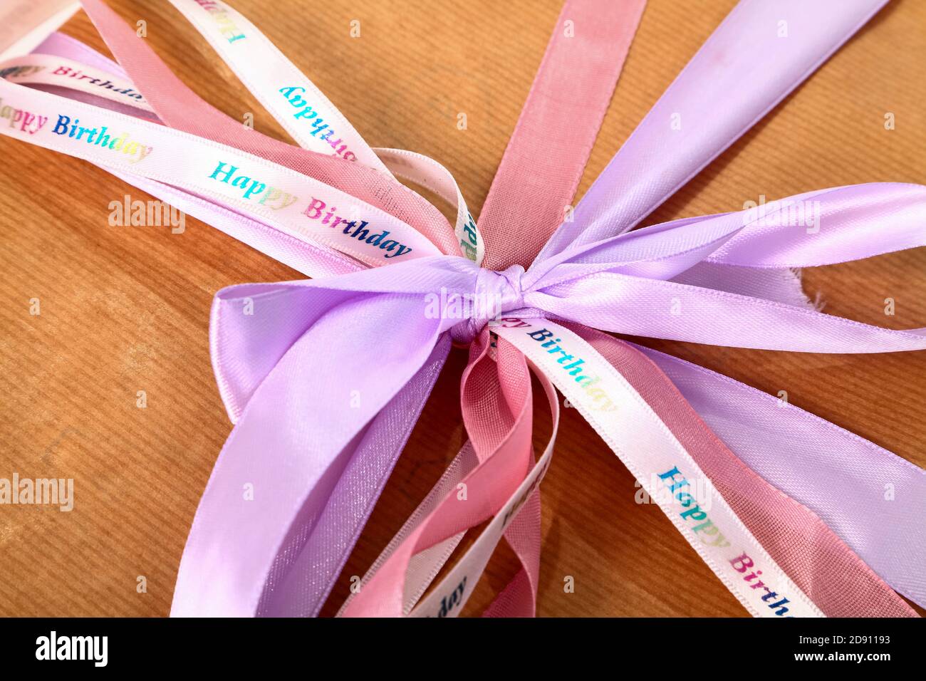 Regalo di compleanno avvolto in semplice carta marrone con nastro legato in un arco Foto Stock