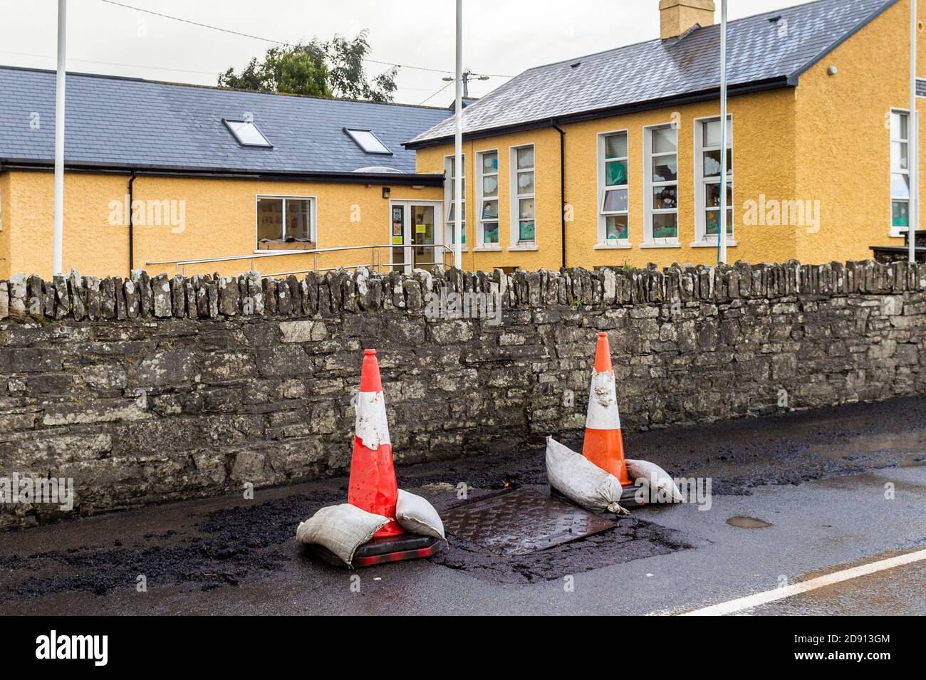 Timoleague, West Cork, Irlanda. 2 Nov 2020. La strada fuori dalla scuola nazionale di Timoleague è stata danneggiata durante la notte a causa di incessanti, forti piogge dopo un Met Eireann Warning. Il consiglio ha posto dei coni stradali per avvertire gli utenti della strada dei danni. Credit: AG News/Alamy Live News Foto Stock
