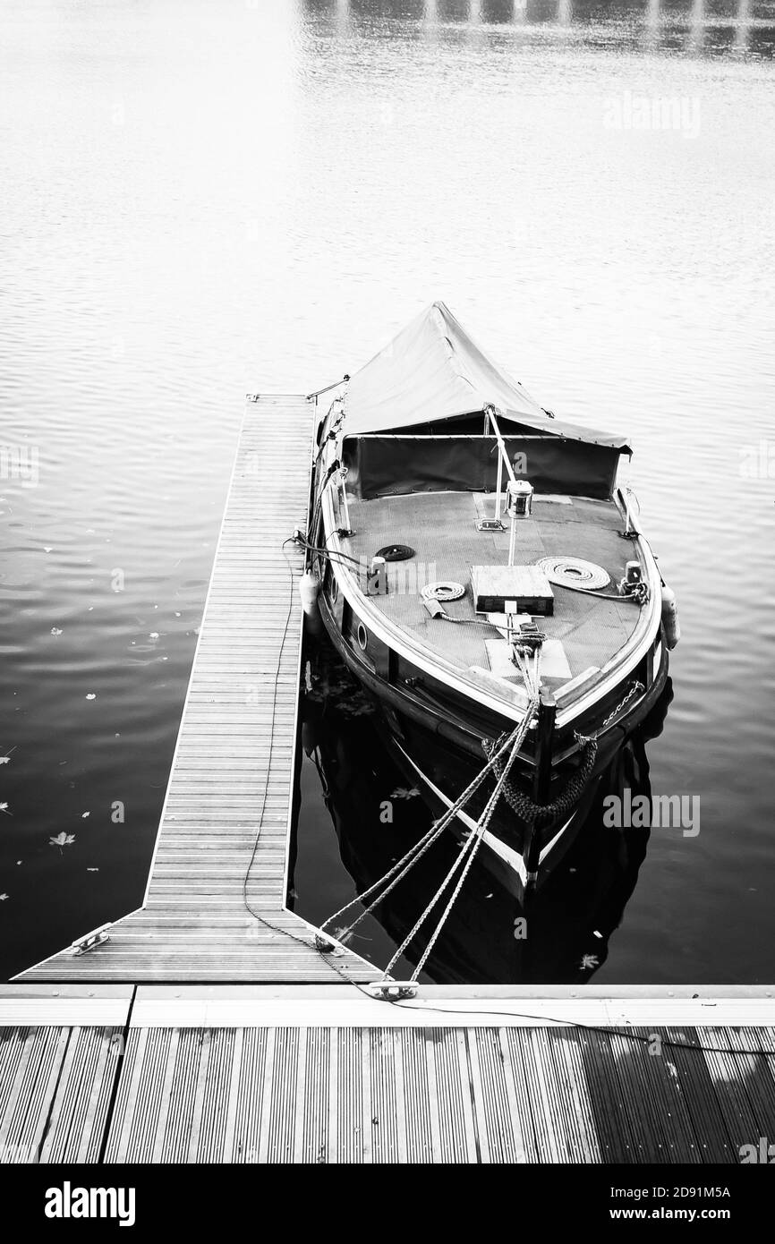 Immagine verticale in scala di grigi di una barca legata a un legno dock  Foto stock - Alamy