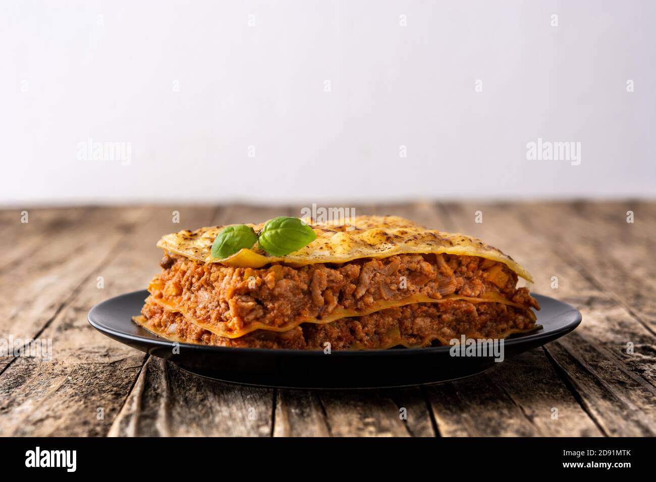 Pezzo di lasagne di carne su tavola di legno Foto Stock
