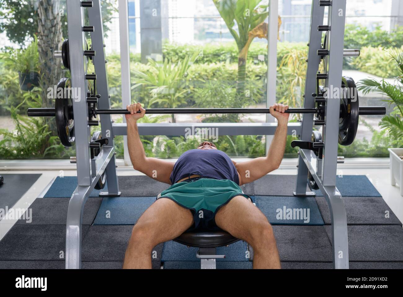 L'uomo persiano bello maturo che fa la pressa della panca alla palestra Foto Stock