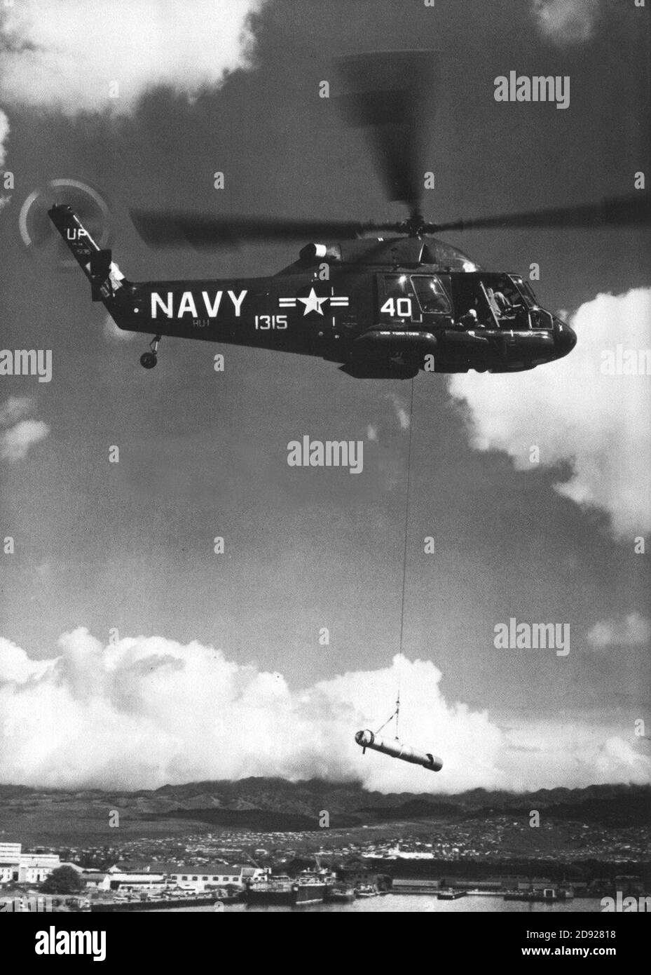 Kaman UH-2B Seasprite di HU-1 sollevamento di un siluro c1965. Foto Stock