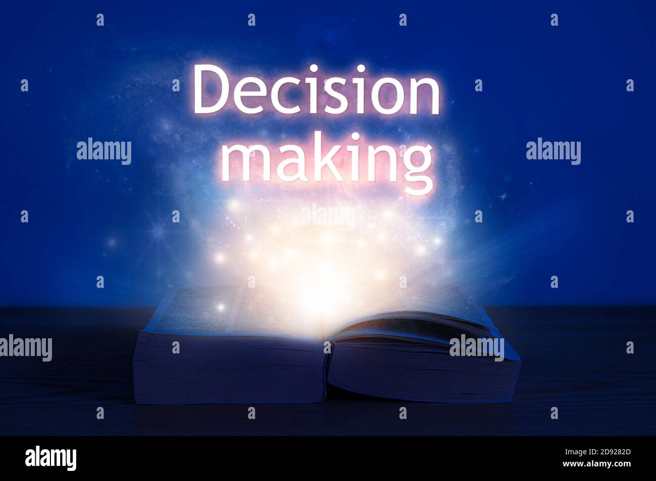 Apri il libro con l'iscrizione decisionale. Luce proveniente dal libro aperto con il processo decisionale delle parole. Foto Stock