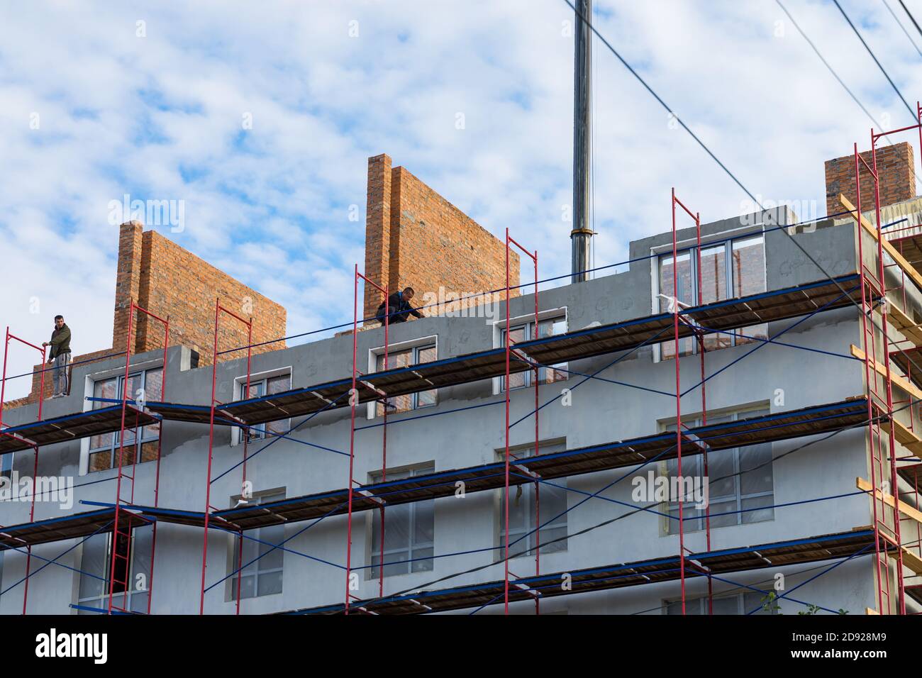 Irpin - Ucraina, Ottobre - 15, 2020: Appaltatori di coperture che lavorano su un tetto domestico per l'installazione di pannelli per shingles di metallo. Foto Stock