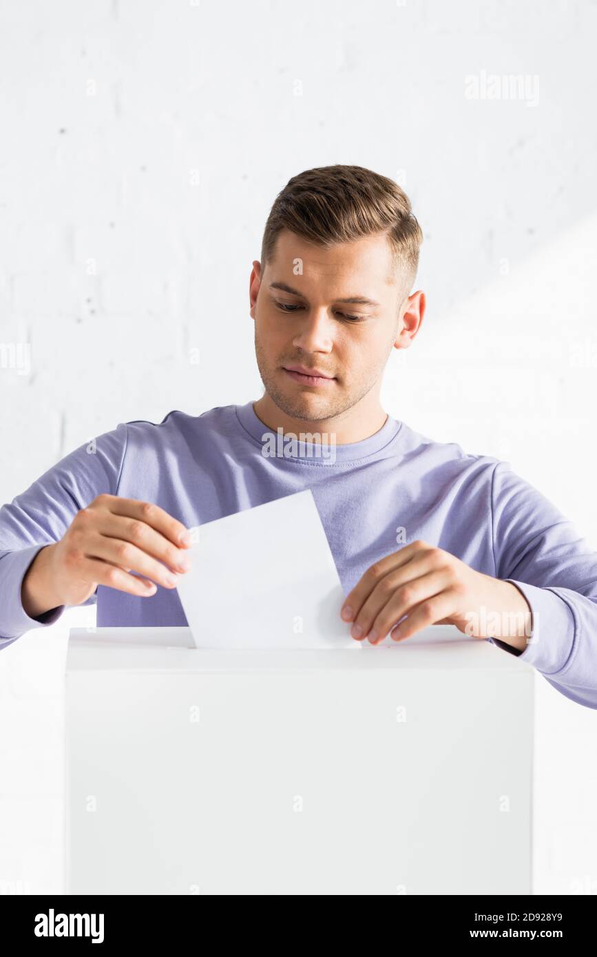 uomo che inserisce il voto nella cabina di polling Foto Stock